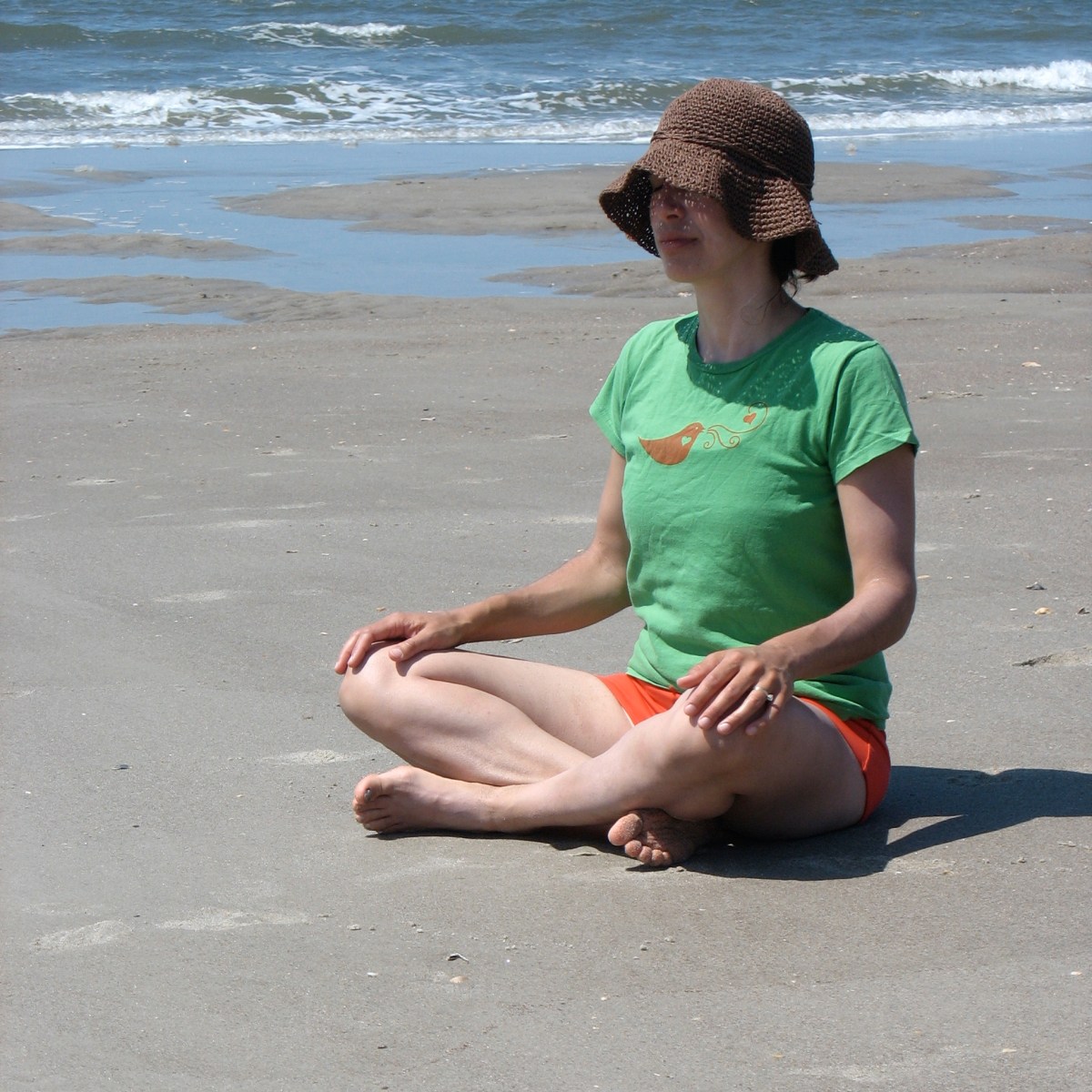 Yoga mama meditating on the beach